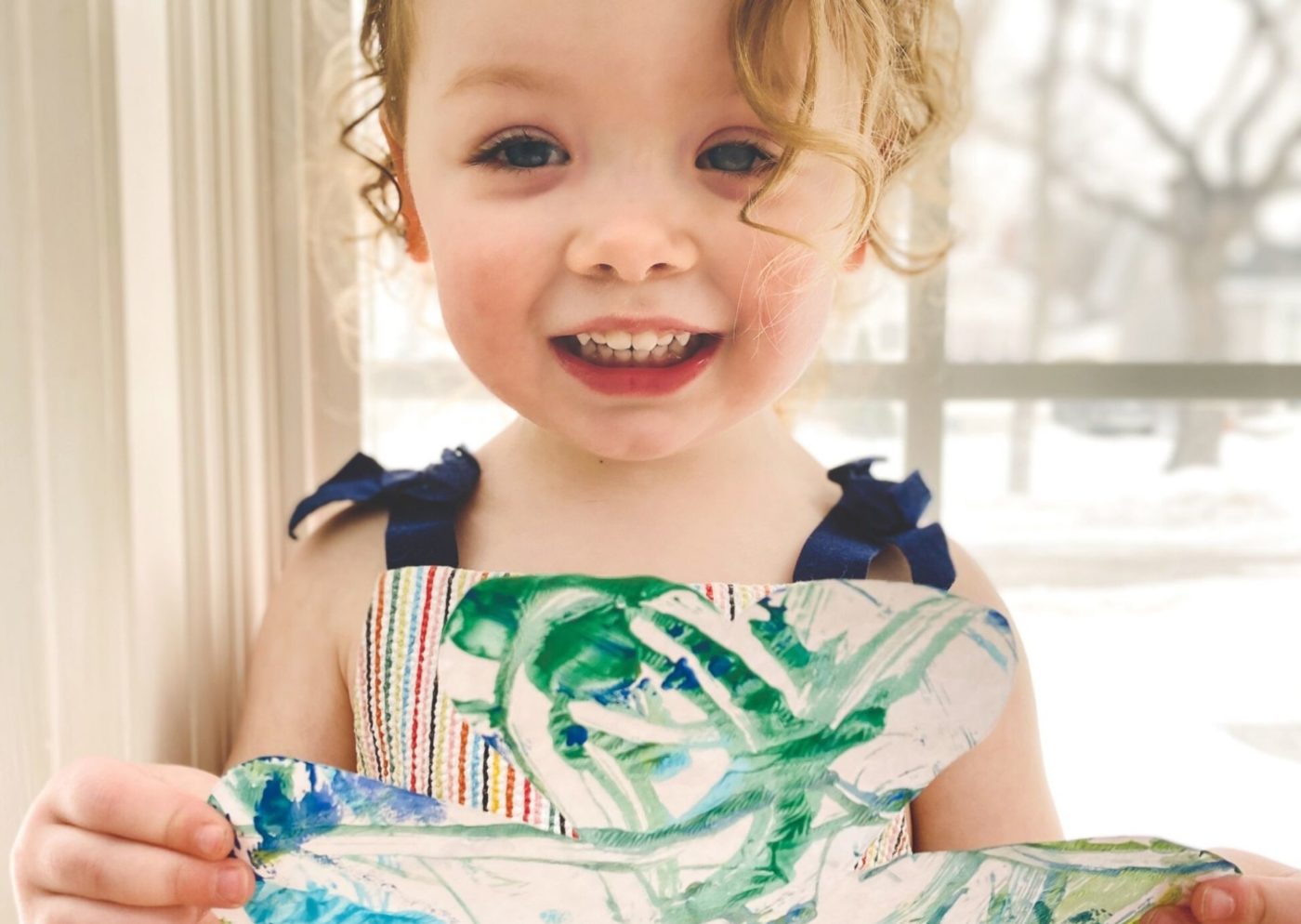 A child shows their artwork.