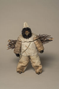 Unidentified artist (Canadian (Hopedale), 20th century). Woman Dressed in Caribou Skin Clothing, 1975–1976, caribou skin, wood, sealskin, wood, cotton, embroidery floss, fake fur, 47 x 40.5 x 15 cm. Collection of the Winnipeg Art Gallery. Gift of JoAnn and Barnett Richling, 2013-108. Photograph: Ernest Mayer, courtesy of the Winnipeg Art Gallery.