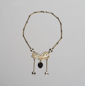 Annie Manning. Inuit (Kinngait), b. 1943. Necklace, 1976. brass, stone (soapstone), ivory. Government of Nunavut Fine Art Collection. On long-term loan to the WAG, 2.77.21