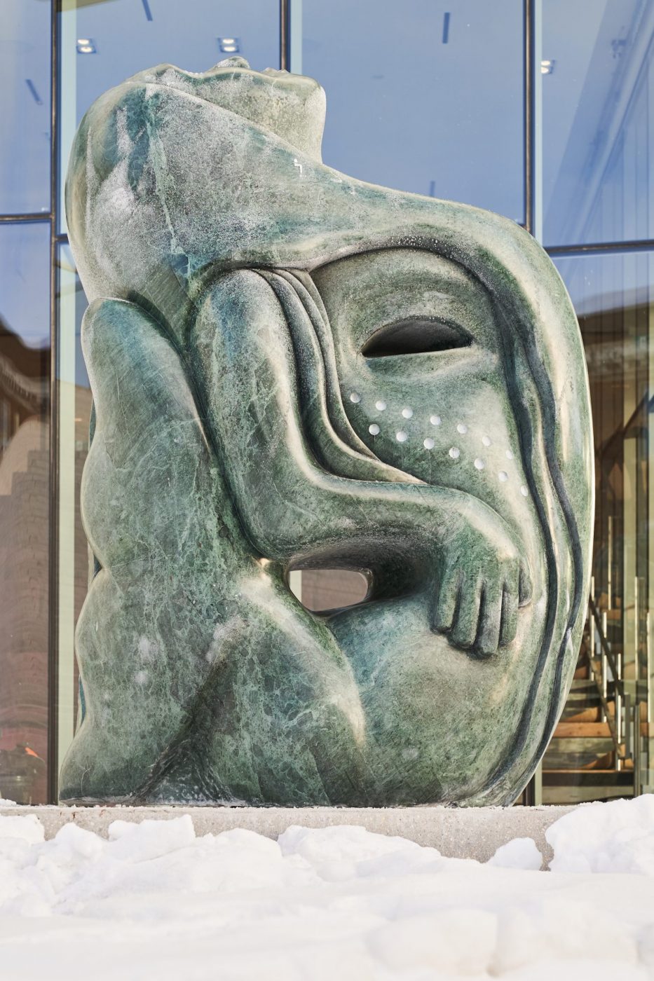 A green Verde Guatemala marble carving outside of the Winnipeg Art Gallery-Qaumajuq that depicts a mermaid.