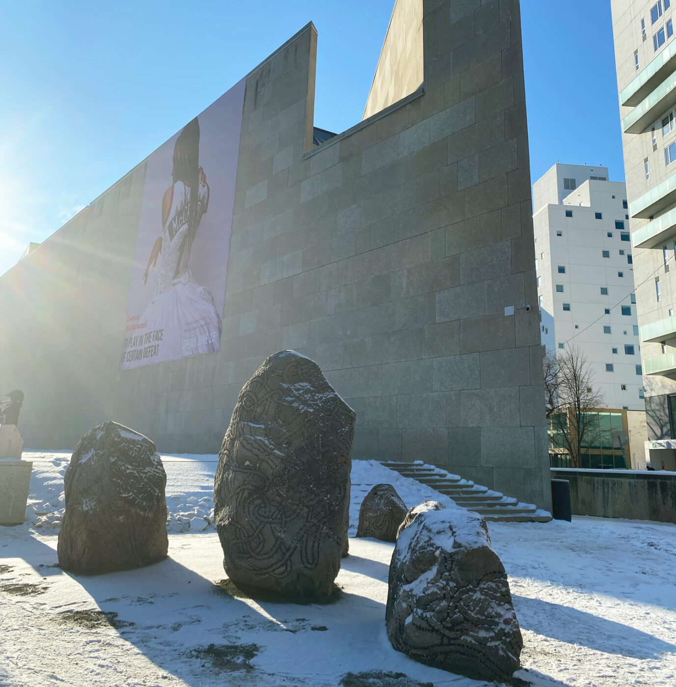 An installation of seven engraved granite boulders outside of the Winnipeg Art Gallery-Qaumajuq.