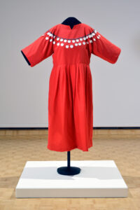 Faye HeavyShield. Red Dress, 2008. nylon, cotton, metal and paper tags, glass beads, 135.5 x 103 x 40 cm. Collection of the Alberta Foundation for the Arts.